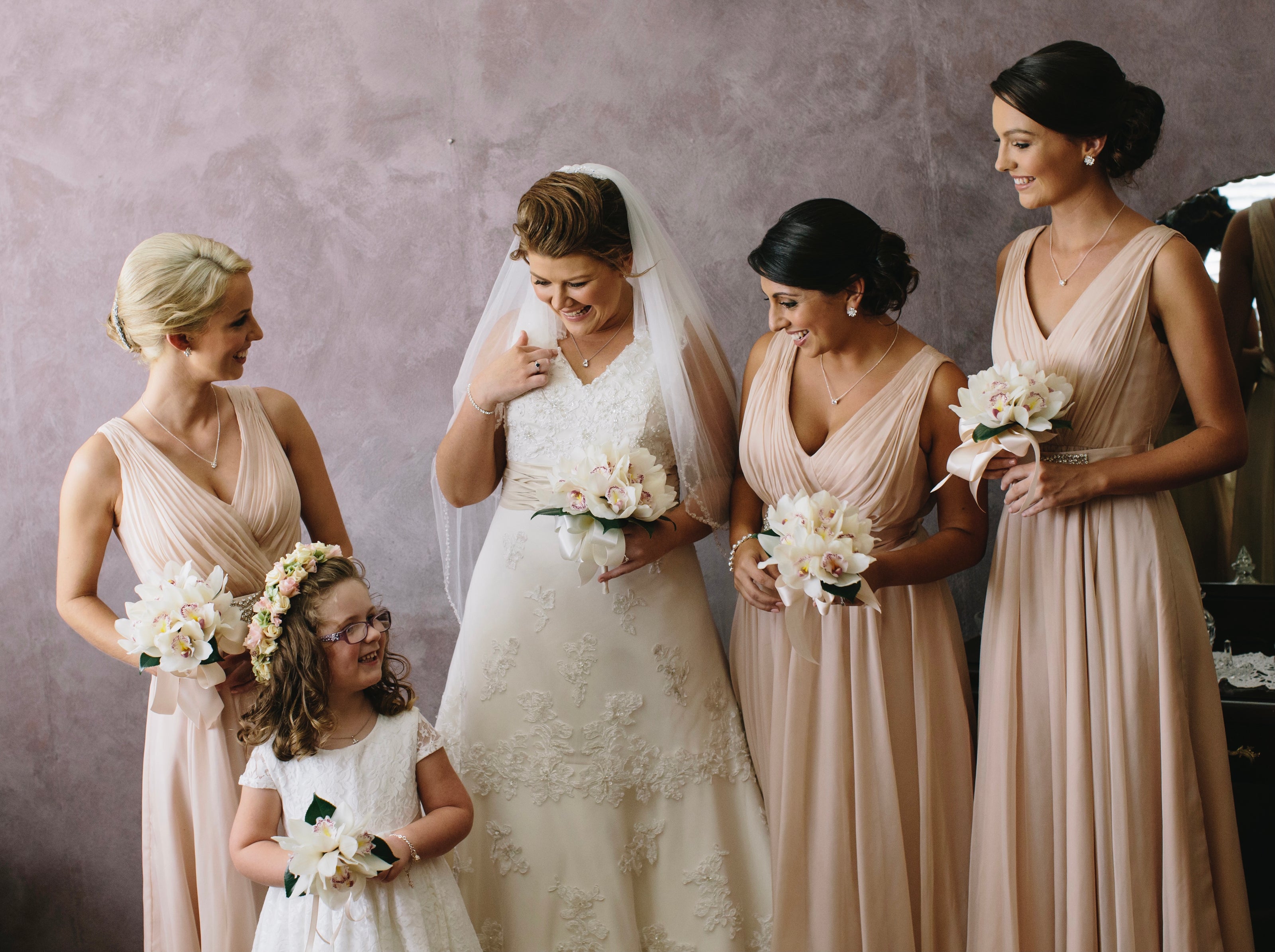 A bride standing with her bridesmaids holding wedding bouquet flowers.