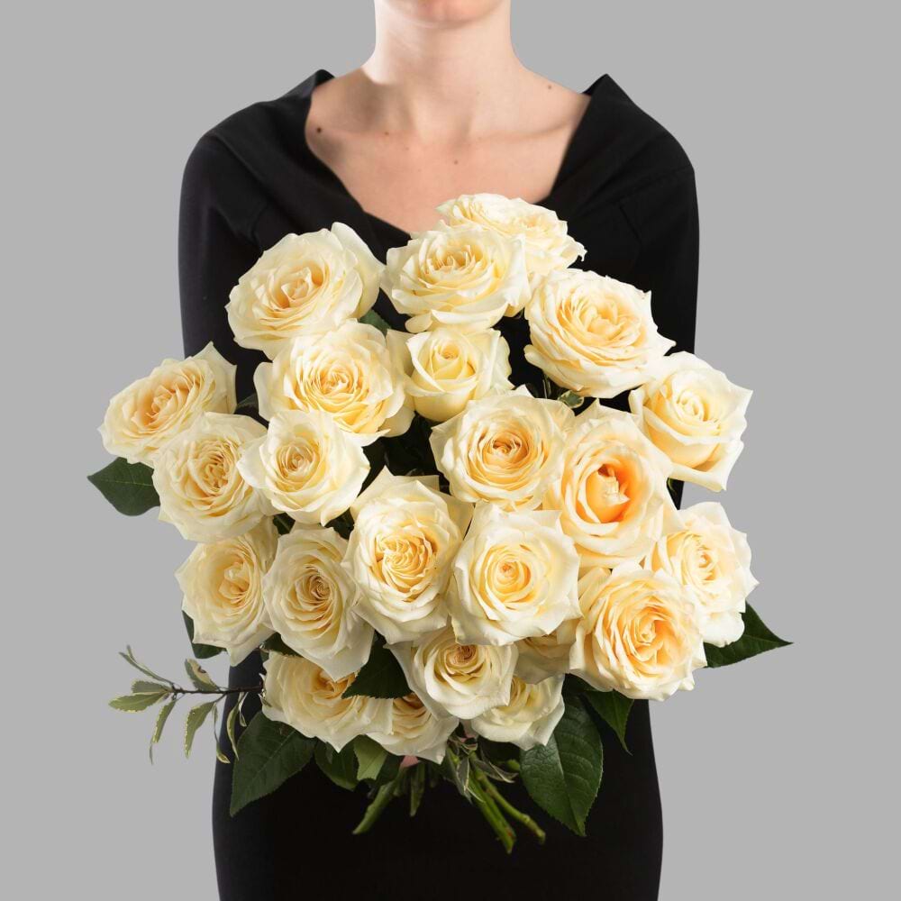 Elegant bouquet of Candlelight roses with large creamy ivory blooms, and lush seasonal foliage.